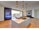 Modern kitchen featuring a waterfall island, pendant lighting, and a view of the living room and balcony at 5000 E Camelback Ridge Rd # 204, Scottsdale, AZ 85251