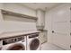 Bright laundry room featuring modern washer and dryer, shaker cabinets and ample counter space at 5000 E Camelback Ridge Rd # 204, Scottsdale, AZ 85251