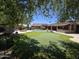 Expansive backyard with a pool, putting green, outdoor fire pit, and covered patio for exceptional outdoor living at 7801 E Davenport Dr, Scottsdale, AZ 85260