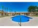 Community pool surrounded by a lush green landscape with palm trees at 8241 N Central Ave # 24, Phoenix, AZ 85020