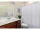 Cozy bathroom features a shower with white curtain, a decorative plant, and white towels at 10065 E Thatcher Ave, Mesa, AZ 85212