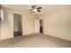 Spacious carpeted bedroom with a ceiling fan and an ensuite bathroom at 10065 E Thatcher Ave, Mesa, AZ 85212