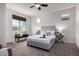 Bright bedroom with a ceiling fan features a comfortable bed, side tables, and a cozy seating area at 10065 E Thatcher Ave, Mesa, AZ 85212