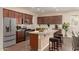 Kitchen features granite countertops, stainless steel appliances, an island with barstool seating, and dark wood cabinets at 10065 E Thatcher Ave, Mesa, AZ 85212