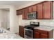 Kitchen features granite countertops, stainless steel appliances, a gas range, and dark wood cabinets at 10065 E Thatcher Ave, Mesa, AZ 85212