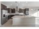 Modern kitchen with dark wood cabinets and a large island at 22531 E Orchard Ln, Queen Creek, AZ 85142