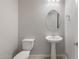 Modern powder room featuring pedestal sink and oval mirror at 22531 E Orchard Ln, Queen Creek, AZ 85142