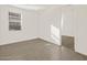 Well-lit bedroom with large window, light tile flooring, and a view into the hallway at 24592 W Bowker St, Buckeye, AZ 85326