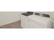 Modern laundry room with efficient, matching washer and dryer appliances and neutral tile flooring at 24592 W Bowker St, Buckeye, AZ 85326