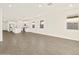 Open concept living area with tile floors, mini-blinds, and modern white kitchen with stainless appliances at 24592 W Bowker St, Buckeye, AZ 85326