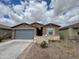 Charming single-story home featuring desert landscaping, a two-car garage, and a welcoming facade at 5636 W Jackalope Ln, Laveen, AZ 85339
