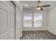 Well-lit bedroom with wood-look floors, a modern ceiling fan, and natural light through windows at 7750 E Broadway Rd # 723, Mesa, AZ 85208