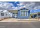 Charming blue home with covered parking, mature cactus landscaping, and a welcoming facade at 7750 E Broadway Rd # 723, Mesa, AZ 85208