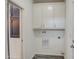 Bright laundry room with overhead cabinets, utility connections, and modern flooring at 7750 E Broadway Rd # 723, Mesa, AZ 85208