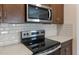 Stainless steel range with modern cooktop and microwave at 17831 W Encinas Ln, Goodyear, AZ 85338