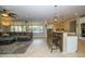 Open kitchen features island with seating, stainless steel appliances, and granite countertops at 2541 E Carob Dr, Gilbert, AZ 85298
