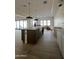 Bright kitchen featuring tile flooring, an island with a farmhouse sink, and white cabinetry, showing light fixtures at 3888 E Weston Ln, San Tan Valley, AZ 85140