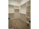 Bright walk-in closet with custom shelving and wood look flooring providing ample storage space at 3888 E Weston Ln, San Tan Valley, AZ 85140