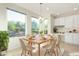 Bright breakfast nook featuring a wooden table, large windows, and modern white cabinetry at 16513 W Windsor Ave, Goodyear, AZ 85395