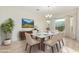 Elegant dining room featuring a marble table, decorative lighting, and a large window for natural light at 16513 W Windsor Ave, Goodyear, AZ 85395