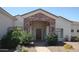 Inviting front entrance with stone archway, wood door, and lush landscaping for added curb appeal at 18029 W San Miguel Ave, Litchfield Park, AZ 85340