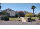 Charming single-story home featuring a manicured lawn, mature trees, and a stone-accented facade at 18029 W San Miguel Ave, Litchfield Park, AZ 85340