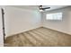 Bright bedroom features plush carpet, a ceiling fan, and a sun-drenched window at 2213 E Janice Way, Phoenix, AZ 85022