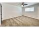 Bright bedroom features plush carpet, a ceiling fan, and a sun-drenched window at 2213 E Janice Way, Phoenix, AZ 85022