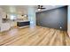Open-concept living room featuring wood-look flooring, a ceiling fan, and access to the kitchen at 2213 E Janice Way, Phoenix, AZ 85022