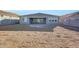 Back exterior view of house with large dirt backyard, patio, and block fence at 28958 N 174Th Ln, Surprise, AZ 85387