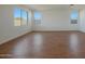 Spacious bedroom with large windows and wood-look tile floors at 28976 N 174Th Ln, Surprise, AZ 85387