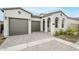 Inviting home featuring a stone driveway, a two-car garage, and an arched entryway at 17643 W Middlebury St, Surprise, AZ 85388