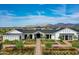 Stunning exterior view of the community clubhouse with beautiful landscaping and mountain views at 17643 W Middlebury St, Surprise, AZ 85388