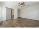 Expansive bedroom boasts wood-look floors, neutral walls, and a barn door leading to a bathroom at 3414 E Virgil Dr, Gilbert, AZ 85298