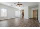 Bright bedroom with wood-look floors, a ceiling fan, and a sliding barn door leading to the bathroom at 3414 E Virgil Dr, Gilbert, AZ 85298