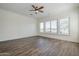 Bright bedroom with wood-look floors, neutral walls, and a ceiling fan at 3414 E Virgil Dr, Gilbert, AZ 85298