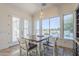 Bright dining area features a rustic wooden table and chairs, with views of the pool and lush backyard through large windows at 3414 E Virgil Dr, Gilbert, AZ 85298
