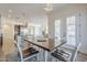 Dining area with a rustic table set, offering a view of the open-concept kitchen and cozy living space with a fireplace at 3414 E Virgil Dr, Gilbert, AZ 85298