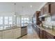 Spacious kitchen features a central island, stainless appliances, dark wood cabinetry, and view of the dining area and backyard at 3414 E Virgil Dr, Gilbert, AZ 85298