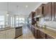 Modern kitchen with white cabinetry, stainless steel appliances, dark wood accents, and a view of the dining area and backyard at 3414 E Virgil Dr, Gilbert, AZ 85298