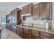 Chef's kitchen boasts dark wood cabinetry, granite countertops, stainless steel appliances, and custom backsplash detailing at 3414 E Virgil Dr, Gilbert, AZ 85298