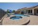 Backyard features a gorgeous pool and a circular spa with a stone surround and poolside seating at 3414 E Virgil Dr, Gilbert, AZ 85298
