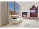 Bright main bedroom with large window, stylish sofa, and a stone fireplace at 5802 E Cholla Ln, Paradise Valley, AZ 85253