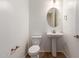 A bathroom features a white toilet and pedestal sink with an oval mirror and tile flooring at 18246 W Cielo Grande Ave, Surprise, AZ 85387