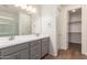 Bathroom vanity with double sinks, drawers and an open doorway to a walk-in closet at 18246 W Cielo Grande Ave, Surprise, AZ 85387