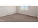 A cozy bedroom is well-lit with neutral carpet and one window at 18246 W Cielo Grande Ave, Surprise, AZ 85387
