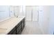 Sleek bathroom with dark wood vanity, white countertop, glass-enclosed shower, and light-colored wood floors at 2445 W Rowel Rd, Phoenix, AZ 85085
