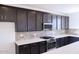 Close-up of kitchen featuring dark cabinets, gas range, white countertop island, and stainless steel microwave at 2445 W Rowel Rd, Phoenix, AZ 85085
