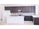 Stylish kitchen featuring dark cabinets, a white island, tile backsplash, and modern stainless steel appliances at 2445 W Rowel Rd, Phoenix, AZ 85085