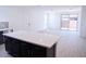 Bright living space showcasing a kitchen island with views of the door to the patio and the front door at 2445 W Rowel Rd, Phoenix, AZ 85085